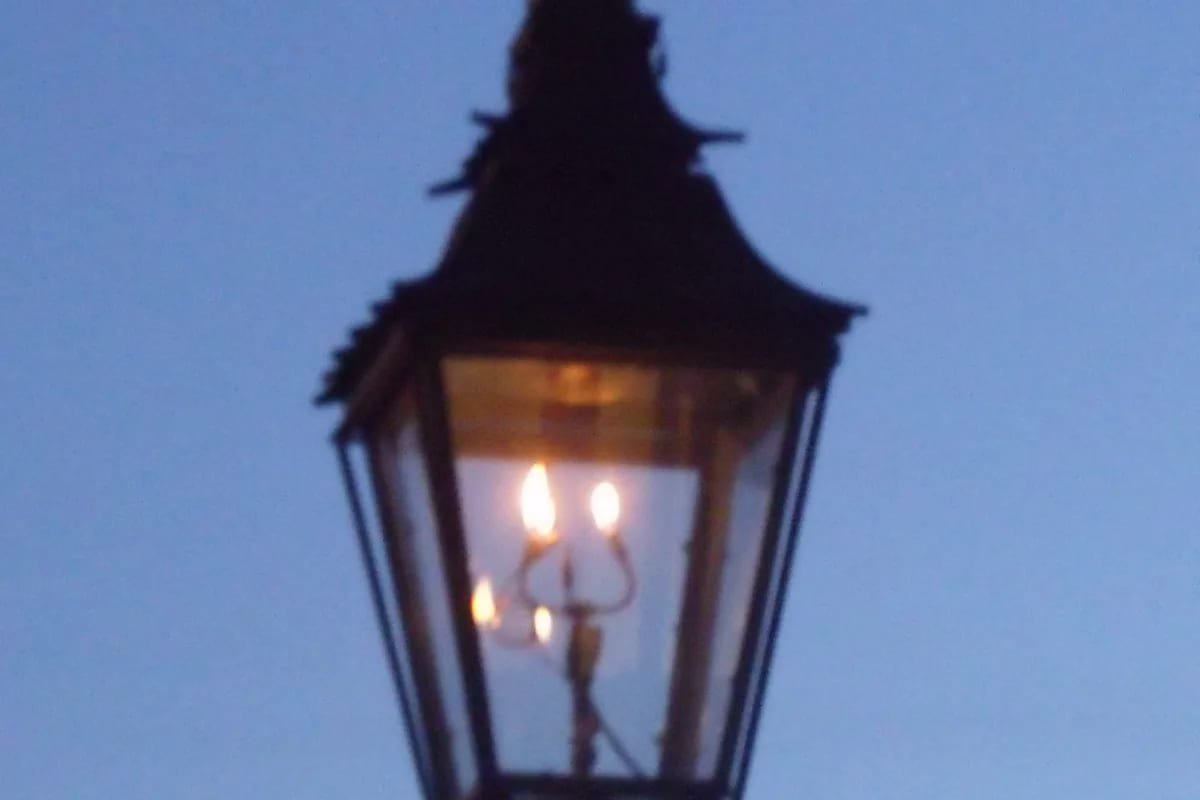 Lampião a gás aceso ao entardecer — botijão P5 portátil para iluminação e emergências